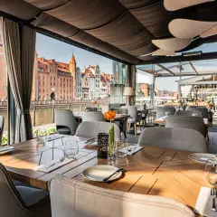 Elegancka restauracja z widokiem na zabytkowe kamienice Gdańska.
