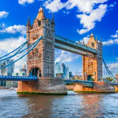 Tower Bridge w Londynie nad Tamizą, z nowoczesnymi wieżowcami w tle.
