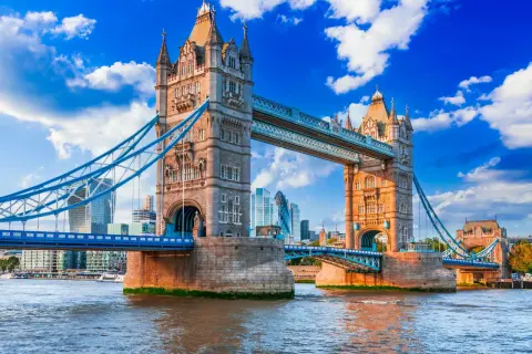 Tower Bridge w Londynie nad Tamizą, z nowoczesnymi wieżowcami w tle.