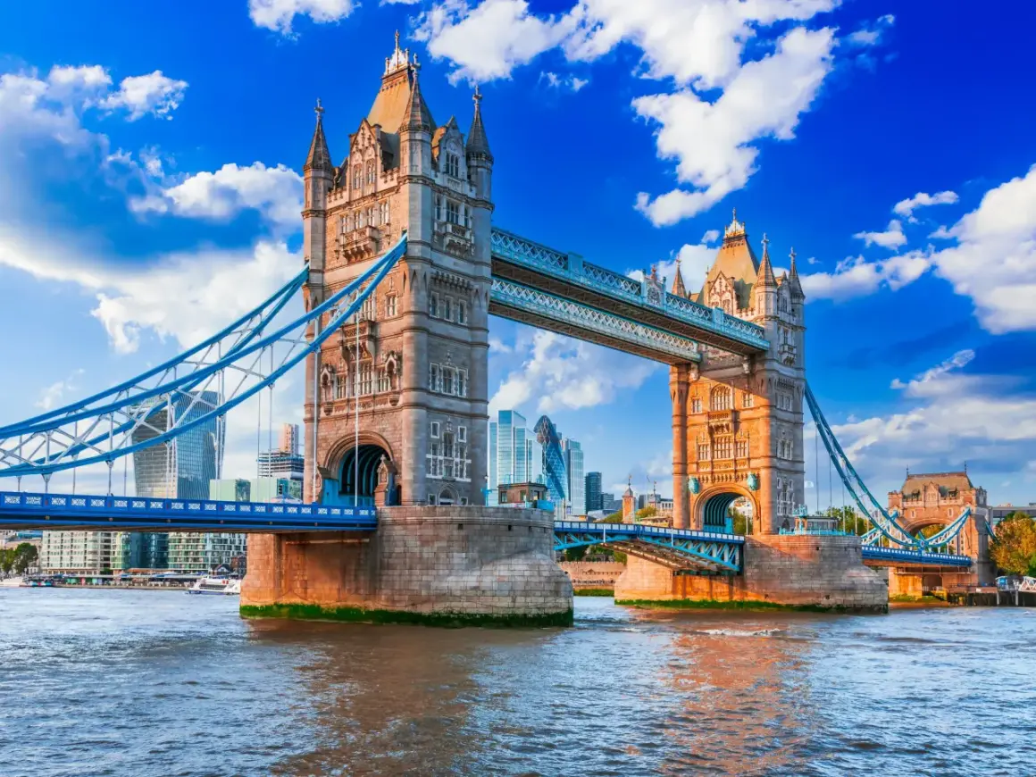 Tower Bridge w Londynie nad Tamizą, z nowoczesnymi wieżowcami w tle.